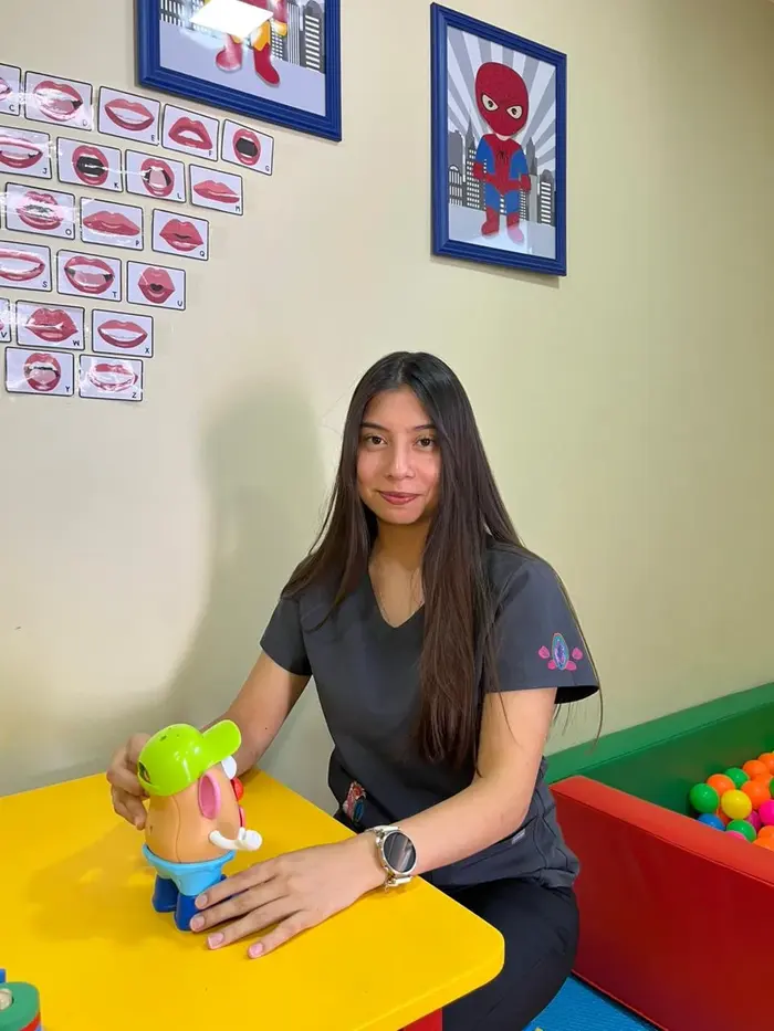 Fonoaudióloga junto a material de estimulación de lenguaje en sala de terapia infantil