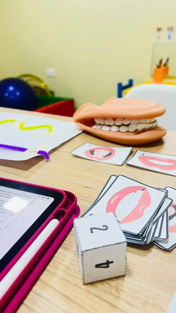Material de terapia de lenguaje: tarjetas de articulación, tablet y modelo de dentadura