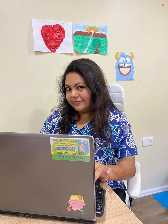 Terapeuta ocupacional trabajando junto a dibujos y material infantil en su oficina